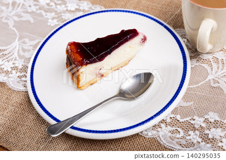 Cherry cheesecake served with sweet berry sauce in cafe Cherry cheesecake served with sweet berry sauce in cafe 140295035