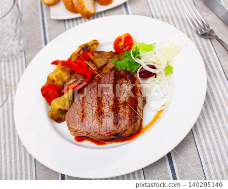 Veal meat cooked over open fire with stewed artichoke and fresh vegetable salad Veal meat cooked over open fire with stewed artichoke and fresh vegetable salad 140295140