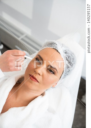 Woman receiving facial treatment at spa in cozy wellness environment Woman receiving facial treatment at spa in cozy wellness environment 140295157