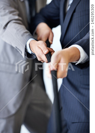 Hands, effort and tug of war with businessmen in studio for collaboration or competition. Teamwork, partnership and challenge with corporate people pulling rope together for strength or struggle Hands, effort and tug of war with businessmen in studio for collaboration or competition. Teamwork, partnership and challenge with corporate people pulling rope together for strength or struggle 140295309