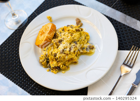Just cooked scrambled eggs with asparagus and mushrooms served on table and ready-to-eat. 140295324