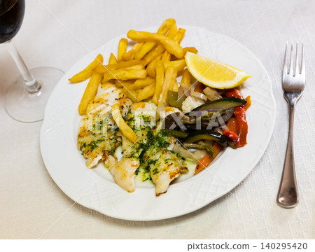 Plate contains fried pink cusk-eel fillet, complemented by French fries and baked vegetables Plate contains fried pink cusk-eel fillet, complemented by French fries and baked vegetables 140295420