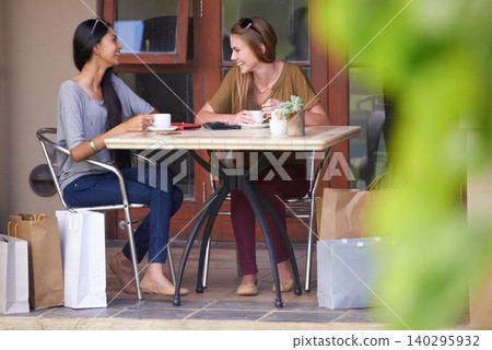 Friends, cafe and shopping bag with fashion, sale and discount in a happy conversation, talking or chat. Young people, women or customer at coffee shop in Europe and happy for holiday or outdoor 140295932