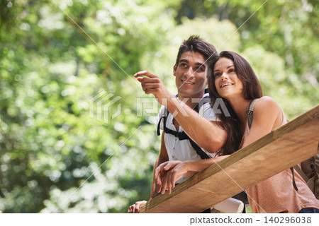 Couple, point and backpack for hiking in forest with smile for thinking, holiday or search by trees. Man, woman and bag for trekking, direction or journey in jungle on bridge for vacation in Colombia Couple, point and backpack for hiking in forest with smile for thinking, holiday or search by trees. Man, woman and bag for trekking, direction or journey in jungle on bridge for vacation in Colombia 140296038