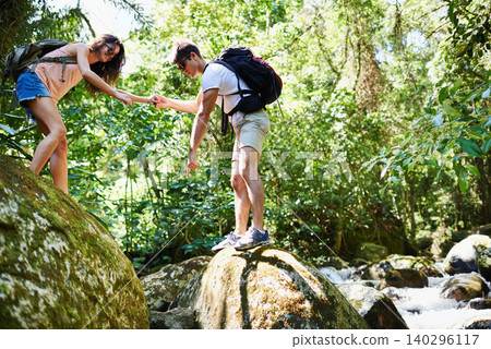 Hiking, help and couple by river in nature for adventure, freedom and explore with backpack outdoors. Forest, travel and man and woman on mountain for holiday, vacation and trekking for wellness 140296117
