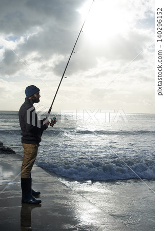 Thinking, fishing and man at a beach with pole for water hobby, recreation or stress relief vacation in nature. Casting, rod and fisherman at sea for travel, adventure or fisher sports in Cape Town Thinking, fishing and man at a beach with pole for water hobby, recreation or stress relief vacation in nature. Casting, rod and fisherman at sea for travel, adventure or fisher sports in Cape Town 140296152