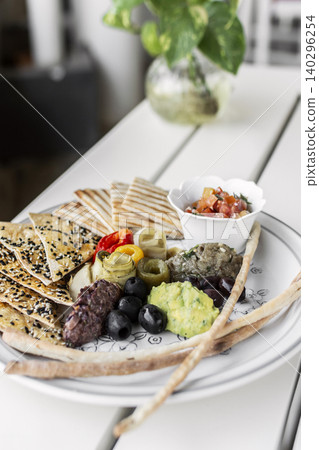 mixed vegan vegetarian mediterranean tapas snack platter on white table in outdoor cafe 140296254