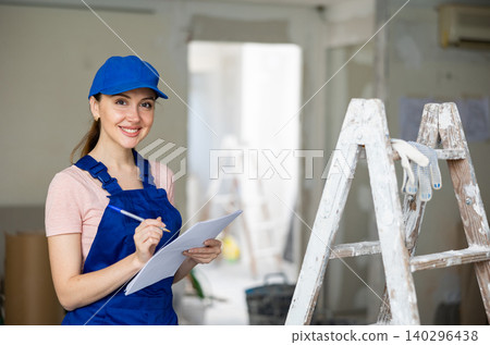 Woman architect checking plan of renovating apartment 140296438