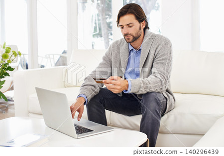 Man, laptop and home with credit card on banking, app and online shopping with discount and sale on delivery. Sofa, living room and website on break with payment for order and food takeaways. Man, laptop and home with credit card on banking, app and online shopping with discount and sale on delivery. Sofa, living room and website on break with payment for order and food takeaways. 140296439