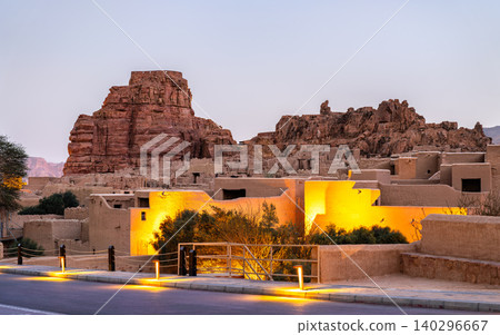 View of the traditional mud brick architecture and historic fort of AlUla Old Town illuminated at twilight in Saudi Arabia. View of the traditional mud brick architecture and historic fort of AlUla Old Town illuminated at twilight in Saudi Arabia. 140296667