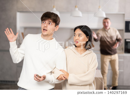 Adult man quarreling with young guy and woman Adult man quarreling with young guy and woman 140297169