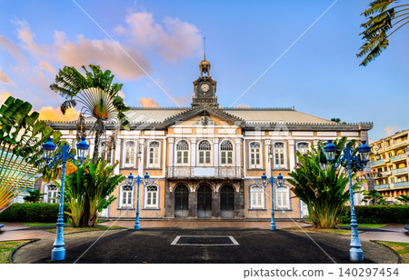The historic town hall, currently Theatre Aime Cesaire surrounded by tropical palm trees under a blue sky at sunset in Fort-de-France, Martinique, the Caribbean The historic town hall, currently Theatre Aime Cesaire surrounded by tropical palm trees under a blue sky at sunset in Fort-de-France, Martinique, the Caribbean 140297454