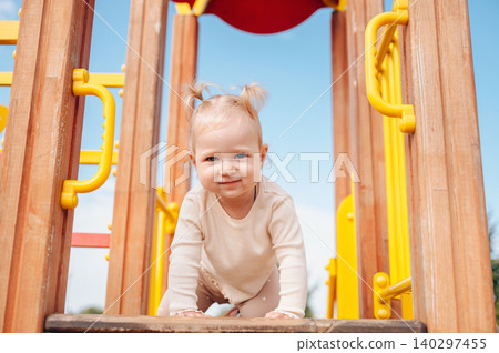 Little girl playing on a playground Little girl playing on a playground 140297455