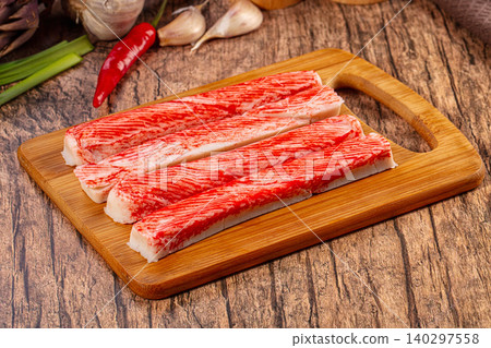 Fresh surimi crab sticks on rustic wooden cutting board with garlic chili Fresh surimi crab sticks on rustic wooden cutting board with garlic chili 140297558