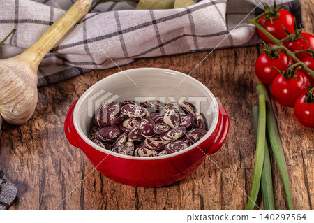 Speckled beans in red bowl, fresh garlic, cherry tomatoes, green onions, rustic wooden table Speckled beans in red bowl, fresh garlic, cherry tomatoes, green onions, rustic wooden table 140297564