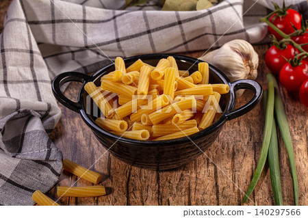 Dry Macaroni Pasta in Black Bowl with Fresh Tomatoes Garlic and Green Onions Dry Macaroni Pasta in Black Bowl with Fresh Tomatoes Garlic and Green Onions 140297566