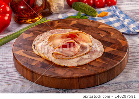 Sliced pork roll on round wooden board with fresh vegetables and spices Sliced pork roll on round wooden board with fresh vegetables and spices 140297581