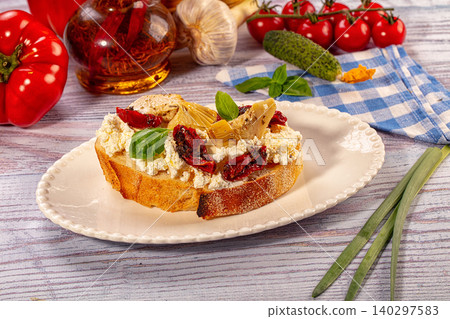 Italian bruschetta with ricotta, sun-dried tomatoes, and artichokes on rustic table Italian bruschetta with ricotta, sun-dried tomatoes, and artichokes on rustic table 140297583