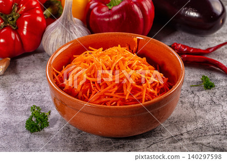 Spicy Korean carrot salad in ceramic bowl with fresh vegetables Spicy Korean carrot salad in ceramic bowl with fresh vegetables 140297598