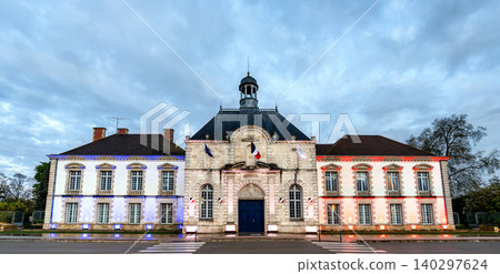 The town hall of Vitry-le-Francois is illuminated with the colors of the French flag under a cloudy dusk sky The town hall of Vitry-le-Francois is illuminated with the colors of the French flag under a cloudy dusk sky 140297624