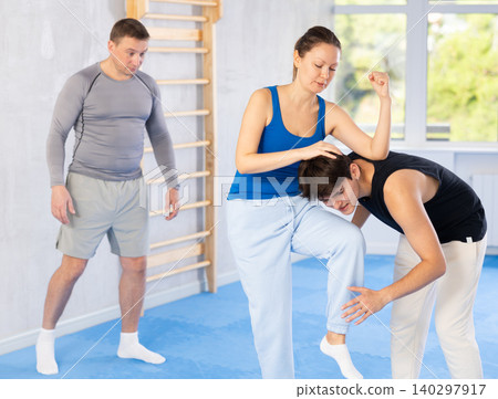 Guy paired up with woman to perform effective impact on pain points while learning self-defense Guy paired up with woman to perform effective impact on pain points while learning self-defense 140297917