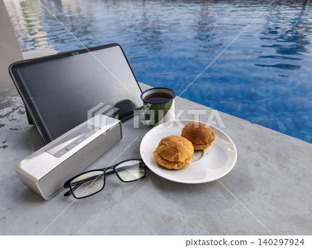 laptop, computer, remote work, digital nomad, freelancer, pool, swimming pool, poolside, edge, coffee, mug, breakfast, pastries, food, glasses, work from anywhere, vacation, holiday, travel, business, 140297924