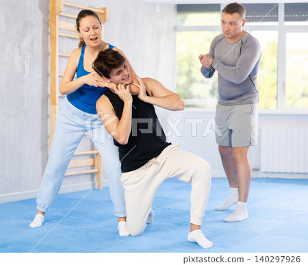 Woman makes a choke hold in self defense trainin Woman makes a choke hold in self defense trainin 140297926
