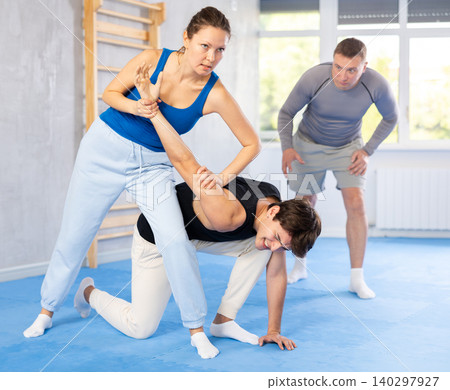 Guy and woman train of performing protection with wring hands during training in self-defense Guy and woman train of performing protection with wring hands during training in self-defense 140297927