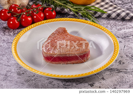 Gourmet seared rare tuna steak on plate with fresh cherry tomatoes and rosemary Gourmet seared rare tuna steak on plate with fresh cherry tomatoes and rosemary 140297969