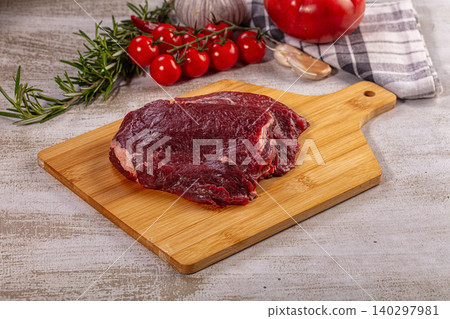 Raw beef cheek on wooden cutting board with fresh vegetables Raw beef cheek on wooden cutting board with fresh vegetables 140297981
