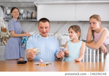 Joyful daughters surrounded dad in kitchen and asked for money Joyful daughters surrounded dad in kitchen and asked for money 140298148