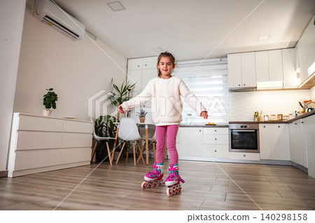 Girl rollerblading on kitchen floor, having fun indoors Girl rollerblading on kitchen floor, having fun indoors 140298158