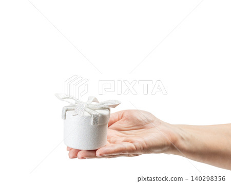 Woman's hand holding a gift box on her palm with the white background. Woman's hand holding a gift box on her palm with the white background. 140298356
