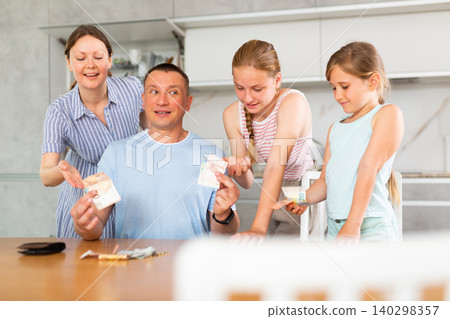 Head of family gives his wife and children pocket money Head of family gives his wife and children pocket money 140298357