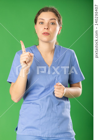 Serious young female medic in blue uniform warning about prohibitions 140298407