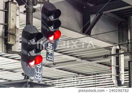 A red departure signal light for trains installed on the station platform. A red departure signal light for trains installed on the station platform. 140298782