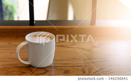 white coffee cup with hot cappuccino coffee on wooden table in coffee cafe. copy space for adding text white coffee cup with hot cappuccino coffee on wooden table in coffee cafe. copy space for adding text 140298841