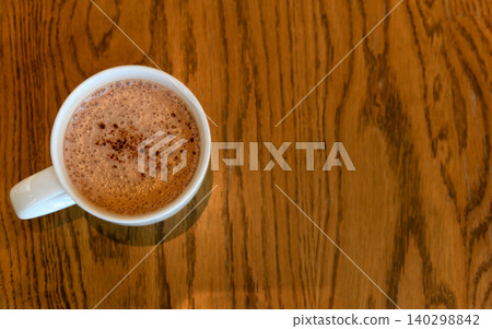 Top view of Hot cocoa on wooden table in coffee cafe. copy space for adding text Top view of Hot cocoa on wooden table in coffee cafe. copy space for adding text 140298842