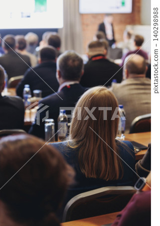 Conference, hall with audience, panel discussion at forum, people on a congress together listen to speaker on stage at convention, plenary session at business lecture seminar, venue for presentation Conference, hall with audience, panel discussion at forum, people on a congress together listen to speaker on stage at convention, plenary session at business lecture seminar, venue for presentation 140298988