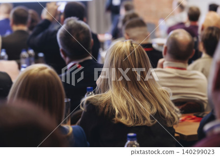 Conference, hall with audience, panel discussion at forum, people on a congress together listen to speaker on stage at convention, plenary session at business lecture seminar, venue for presentation Conference, hall with audience, panel discussion at forum, people on a congress together listen to speaker on stage at convention, plenary session at business lecture seminar, venue for presentation 140299023