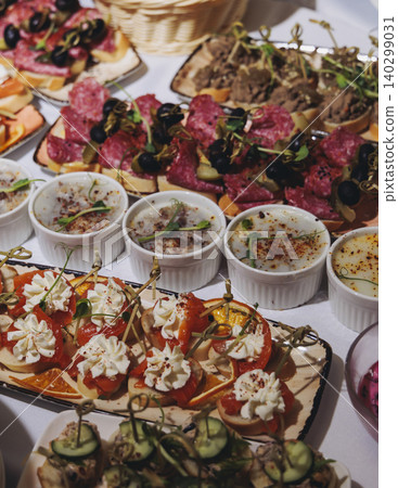 Traditional Russian cuisine dishes on a New Year table, dressed herring salad, kholodets brawn, russian snacks, olivier salad and homemade pickles on catering table banquet, party event celebration Traditional Russian cuisine dishes on a New Year table, dressed herring salad, kholodets brawn, russian snacks, olivier salad and homemade pickles on catering table banquet, party event celebration 140299031