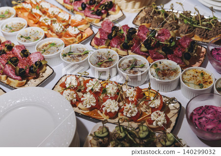 Traditional Russian cuisine dishes on a New Year table, dressed herring salad, kholodets brawn, russian snacks, olivier salad and homemade pickles on catering table banquet, party event celebration Traditional Russian cuisine dishes on a New Year table, dressed herring salad, kholodets brawn, russian snacks, olivier salad and homemade pickles on catering table banquet, party event celebration 140299032