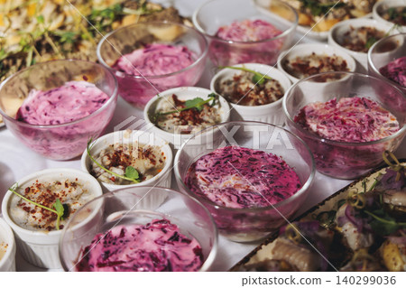 Traditional Russian cuisine dishes on a New Year table, dressed herring salad, kholodets brawn, russian snacks, olivier salad and homemade pickles on catering table banquet, party event celebration Traditional Russian cuisine dishes on a New Year table, dressed herring salad, kholodets brawn, russian snacks, olivier salad and homemade pickles on catering table banquet, party event celebration 140299036