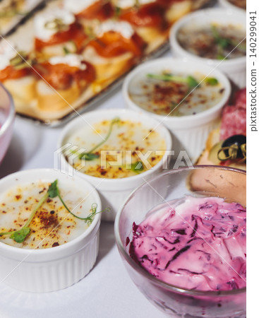Traditional Russian cuisine dishes on a New Year table, dressed herring salad, kholodets brawn, russian snacks, olivier salad and homemade pickles on catering table banquet, party event celebration Traditional Russian cuisine dishes on a New Year table, dressed herring salad, kholodets brawn, russian snacks, olivier salad and homemade pickles on catering table banquet, party event celebration 140299041
