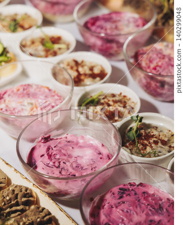 Traditional Russian cuisine dishes on a New Year table, dressed herring salad, kholodets brawn, russian snacks, olivier salad and homemade pickles on catering table banquet, party event celebration Traditional Russian cuisine dishes on a New Year table, dressed herring salad, kholodets brawn, russian snacks, olivier salad and homemade pickles on catering table banquet, party event celebration 140299048