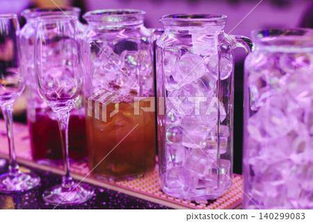 Barman mixing and pouring drinks and beverages, beautiful row line of different coloured lemonades in a jar, liquor alcohol cocktails on a party in bar, catering banquet on event, mocktails in a jug Barman mixing and pouring drinks and beverages, beautiful row line of different coloured lemonades in a jar, liquor alcohol cocktails on a party in bar, catering banquet on event, mocktails in a jug 140299083