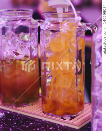 Barman mixing and pouring drinks and beverages, beautiful row line of different coloured lemonades in a jar, liquor alcohol cocktails on a party in bar, catering banquet on event, mocktails in a jug 140299084