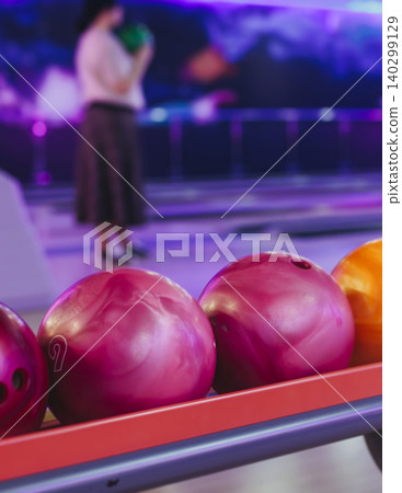 Bowling club play, group team of friends and colleagues playing, throwing a ball on the bowling alley lane, ball and pins, corporate party event in a mall amusement game center, tournament competition Bowling club play, group team of friends and colleagues playing, throwing a ball on the bowling alley lane, ball and pins, corporate party event in a mall amusement game center, tournament competition 140299129