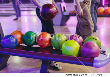 Bowling club play, group team of friends and colleagues playing, throwing a ball on the bowling alley lane, ball and pins, corporate party event in a mall amusement game center, tournament competition Bowling club play, group team of friends and colleagues playing, throwing a ball on the bowling alley lane, ball and pins, corporate party event in a mall amusement game center, tournament competition 140299136