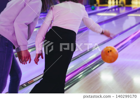 Bowling club play, group team of friends and colleagues playing, throwing a ball on the bowling alley lane, ball and pins, corporate party event in a mall amusement game center, tournament competition Bowling club play, group team of friends and colleagues playing, throwing a ball on the bowling alley lane, ball and pins, corporate party event in a mall amusement game center, tournament competition 140299170